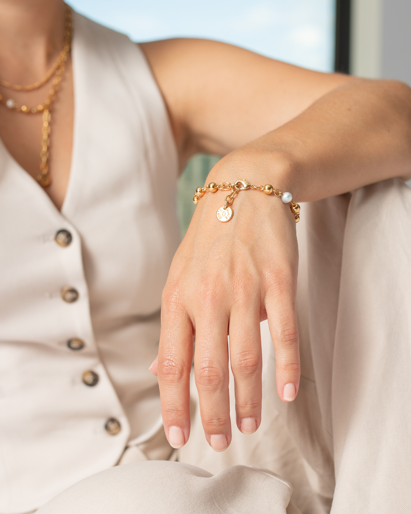 Armband Bubble, am Handgelenk getragen in Gold mit Perle und Karabingerverschluss von Runte Schmuck